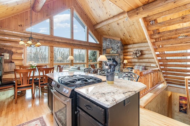 kitchen with a center island, light hardwood / wood-style flooring, a notable chandelier, beam ceiling, and stainless steel range with gas stovetop