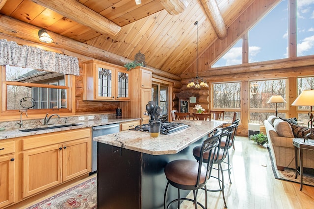 kitchen featuring decorative light fixtures, light wood-type flooring, appliances with stainless steel finishes, a notable chandelier, and a kitchen island