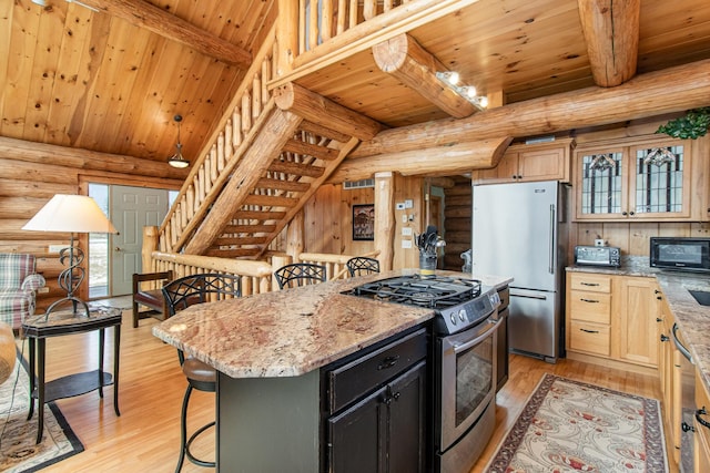 kitchen featuring light stone countertops, a center island, stainless steel appliances, and light wood-type flooring