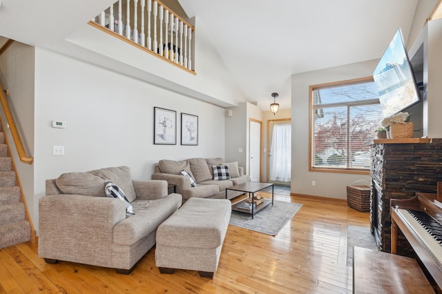 living room featuring a high ceiling and light hardwood / wood-style flooring