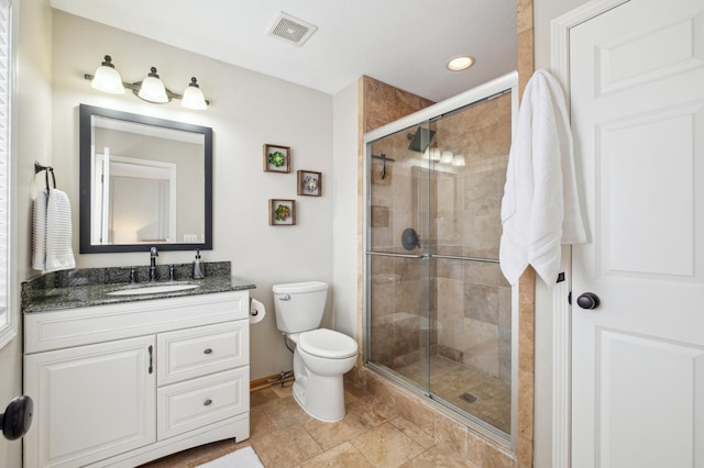 bathroom with an enclosed shower, vanity, and toilet