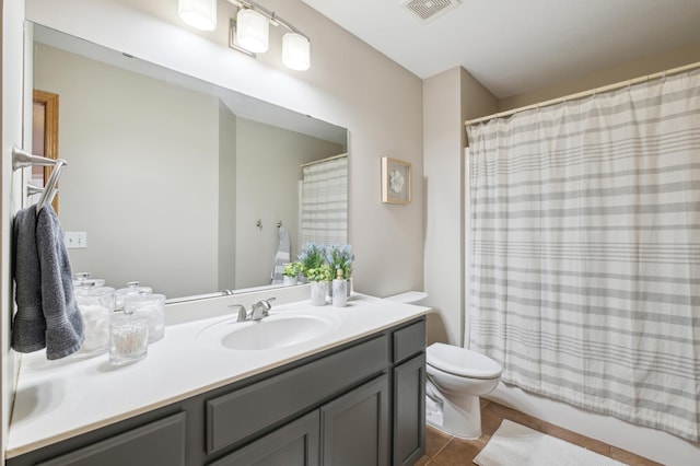 bathroom featuring tile patterned flooring, vanity, walk in shower, and toilet