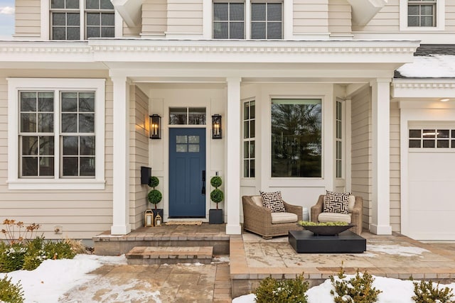 snow covered property entrance featuring a garage