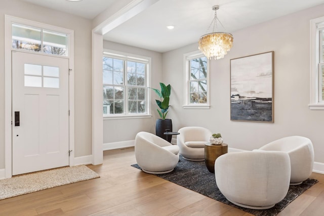 entrance foyer featuring light hardwood / wood-style flooring and a notable chandelier