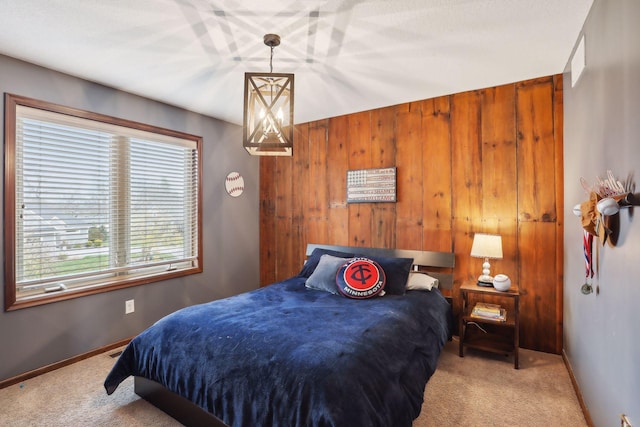 bedroom with light colored carpet and wood walls