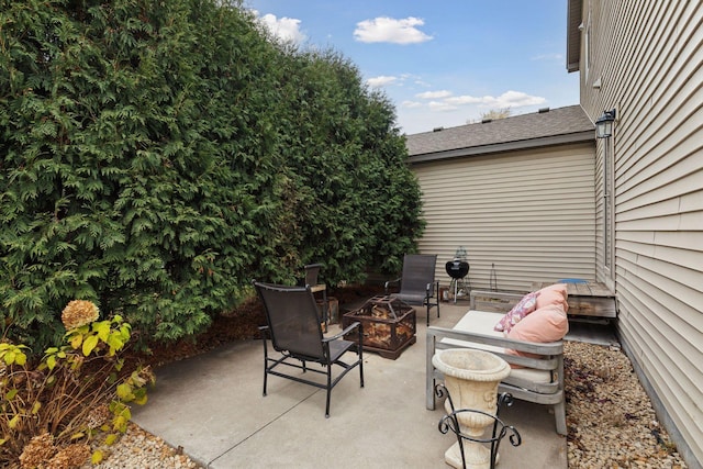 view of patio with an outdoor living space with a fire pit