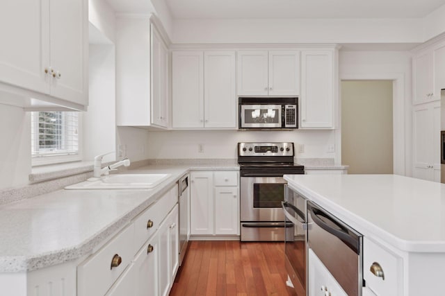 kitchen featuring white cabinets, light wood-type flooring, stainless steel appliances, and sink