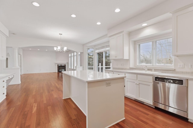 kitchen with white cabinets, dishwasher, sink, and decorative light fixtures