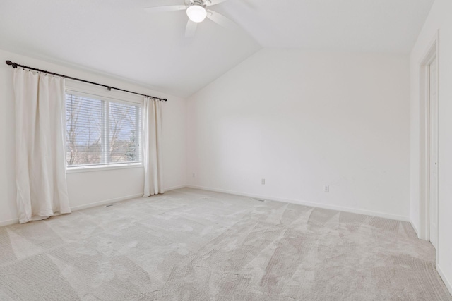 spare room featuring ceiling fan, light colored carpet, and lofted ceiling