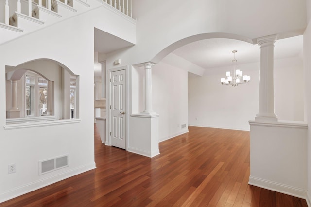 spare room featuring an inviting chandelier and dark wood-type flooring