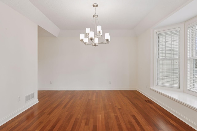 unfurnished room featuring dark hardwood / wood-style floors and a notable chandelier