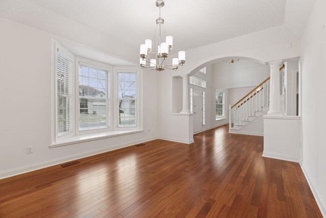 unfurnished dining area featuring dark hardwood / wood-style flooring, a healthy amount of sunlight, and a notable chandelier