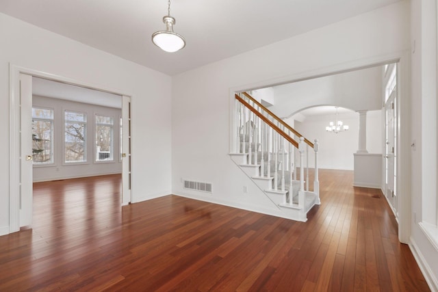 interior space with ornate columns and dark hardwood / wood-style flooring