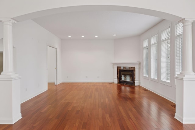 unfurnished living room featuring hardwood / wood-style floors, a fireplace, and a healthy amount of sunlight