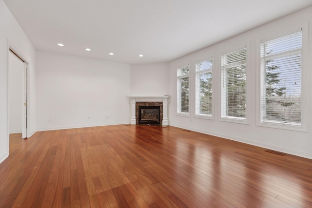 unfurnished living room with a premium fireplace and hardwood / wood-style flooring