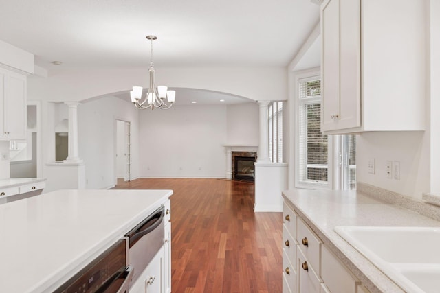 kitchen featuring decorative light fixtures, white cabinetry, a fireplace, and a chandelier