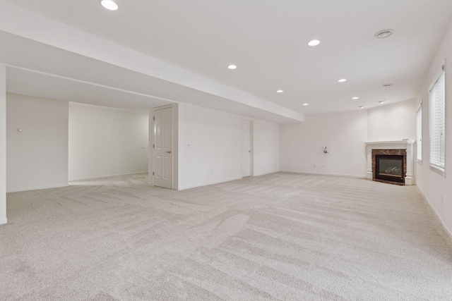 unfurnished living room featuring light carpet and a high end fireplace