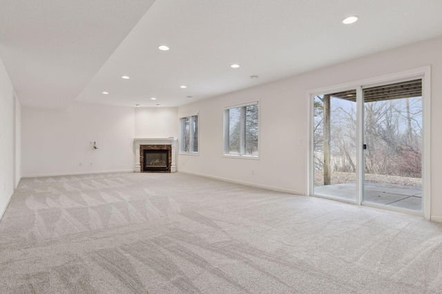 unfurnished living room with a fireplace and light colored carpet