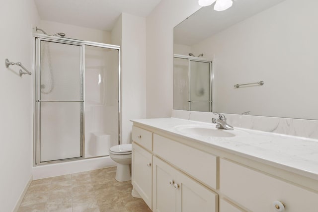 bathroom featuring vanity, toilet, and a shower with shower door