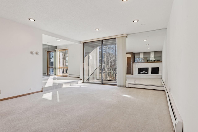 unfurnished living room with a baseboard heating unit and light colored carpet