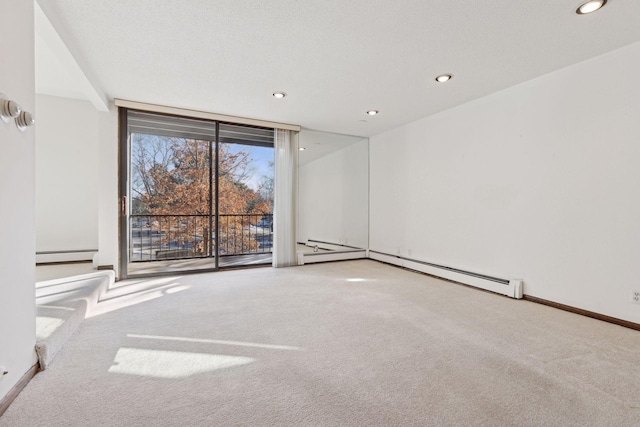 carpeted empty room featuring floor to ceiling windows and baseboard heating