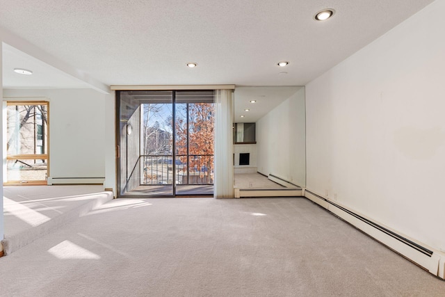 empty room with light carpet, a textured ceiling, and baseboard heating