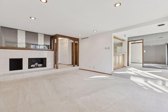 unfurnished living room featuring a tiled fireplace and light carpet