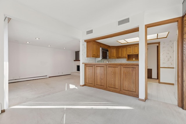 kitchen featuring light carpet and a baseboard heating unit