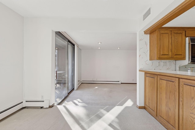 kitchen with light carpet and a baseboard heating unit