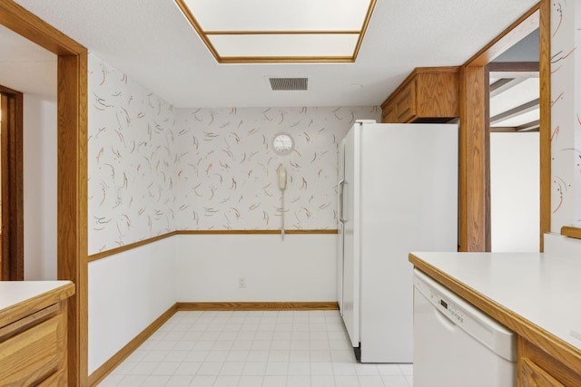 kitchen featuring a textured ceiling and white appliances