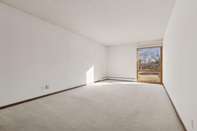 carpeted spare room with a baseboard heating unit and a textured ceiling