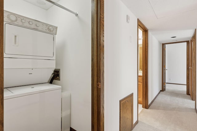 washroom featuring light carpet and stacked washer and clothes dryer