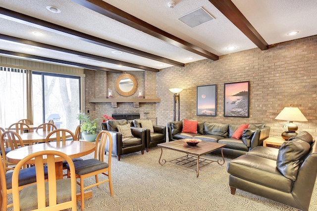 living room with beam ceiling, a fireplace, a textured ceiling, and brick wall