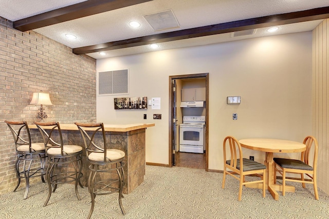 bar featuring beam ceiling, a textured ceiling, brick wall, and white range with electric stovetop