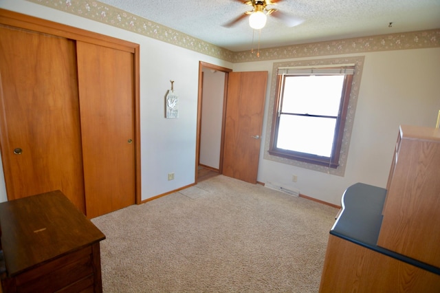 carpeted bedroom featuring ceiling fan, a textured ceiling, and a closet