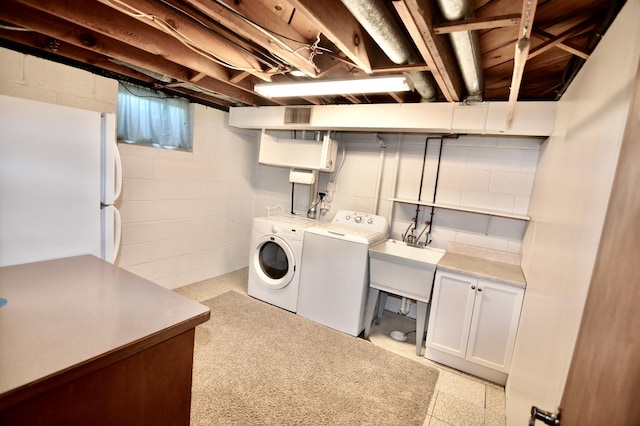 laundry area with sink, independent washer and dryer, and cabinets