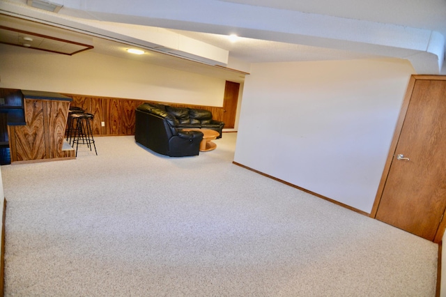 unfurnished room featuring wood walls and carpet flooring