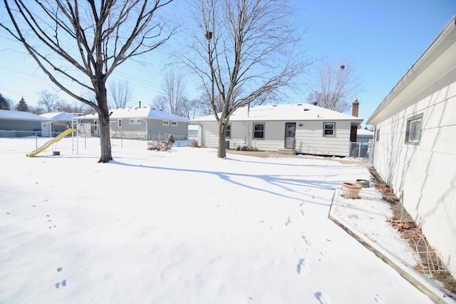 snow covered property featuring a playground