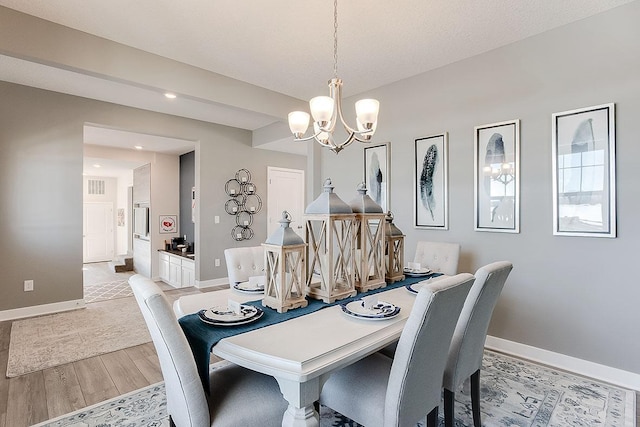 dining area with a chandelier and light hardwood / wood-style floors