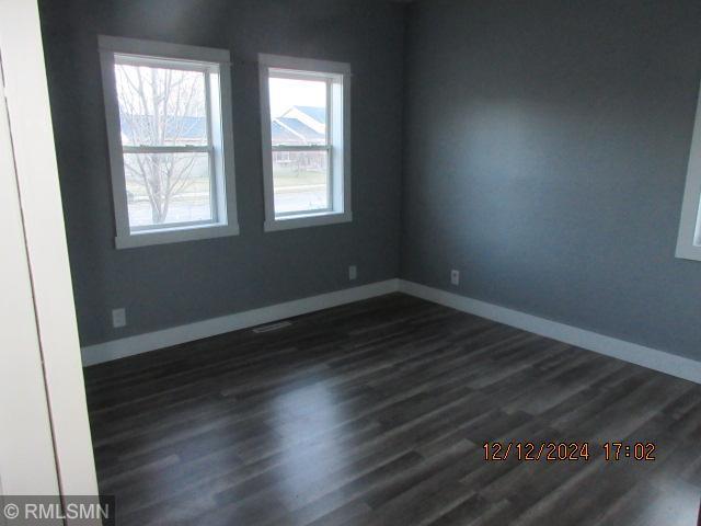 spare room featuring dark wood-type flooring