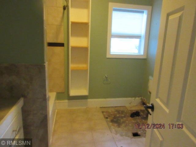 bathroom with tile patterned floors and a shower