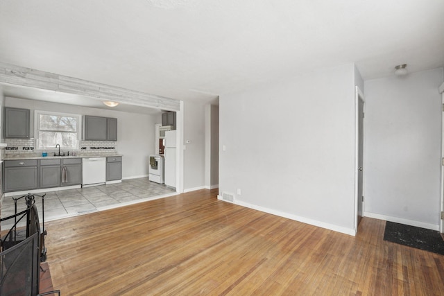 living room featuring sink and light hardwood / wood-style flooring