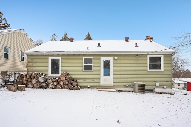 snow covered rear of property with central AC