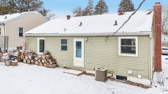 snow covered house with central air condition unit