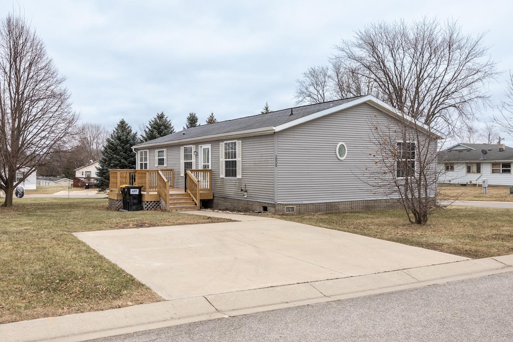 manufactured / mobile home with a front yard and a deck