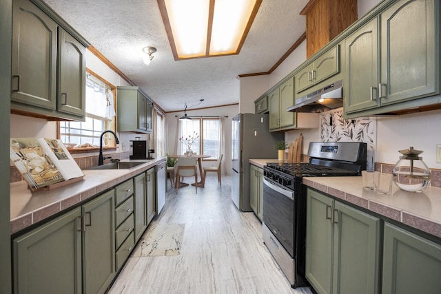 kitchen with a wealth of natural light, a textured ceiling, appliances with stainless steel finishes, and green cabinetry