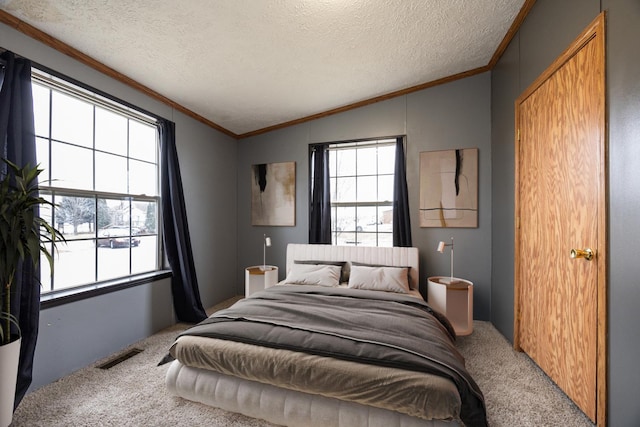 carpeted bedroom with multiple windows, a textured ceiling, and vaulted ceiling