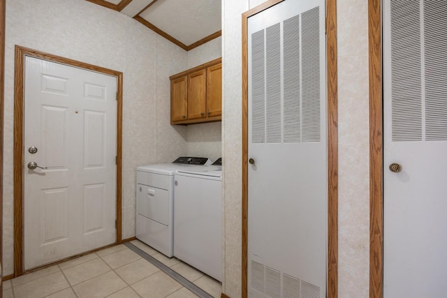 laundry room with cabinets, light tile patterned floors, washing machine and dryer, and a textured ceiling