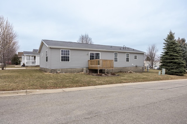 manufactured / mobile home with a deck and a front lawn