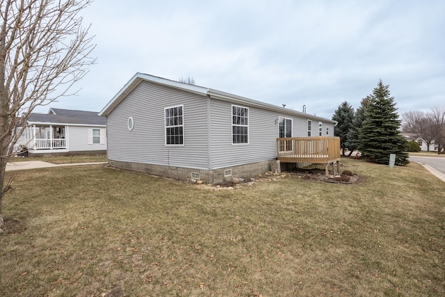 view of side of home with a lawn and a deck